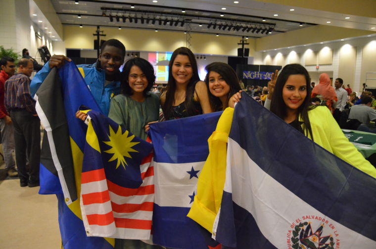   A group of international students celebrate International Night by showing their nation’s flag. Several flags lined the front of the stage where the performances were held.