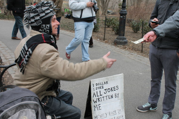   In Central Park, advertising manager Brady Krumwiede and former sports editor Justin Harned give a man a dollar in exchange for a joke. 