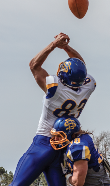 Senior wide receiver Jason Schneider leaps for the ball as he is hit by senior defensive back Jake Gentile. 
