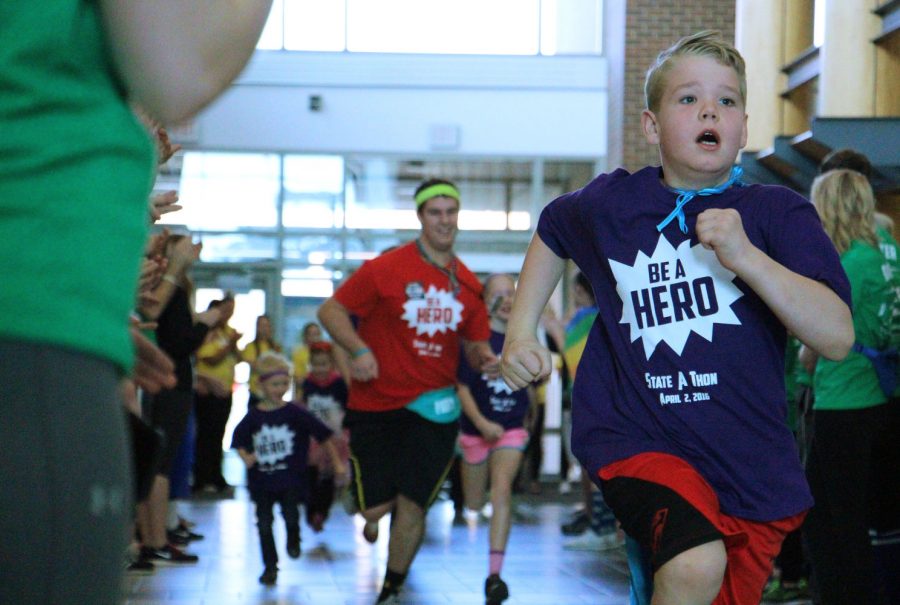 Christian Postma, brain cancer survivor, runs down Main Street in The Union as students clap in support for the opening ceremony for State-A-Thon April 2, 2019. Kyle Schiltz, State-A-Thon morale co-chair, runs behind him.