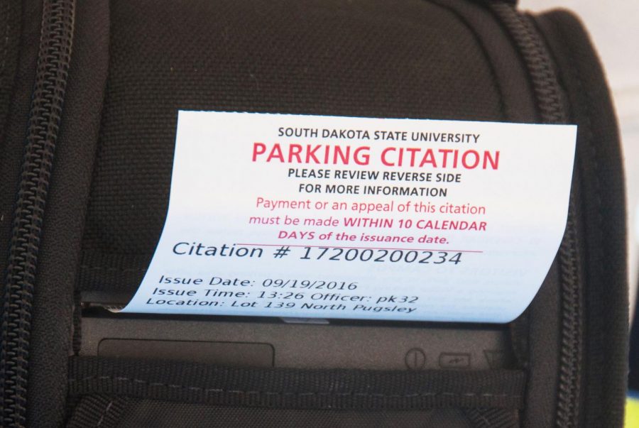 Parking+Enforcement+Specialist+Jeff+VanGerpen+places+a+ticket+onto+a+vehicle+on+Sept.+19.+Typical+violations+include+parking+in+the+wrong+lot+or+not+having+a+permit.