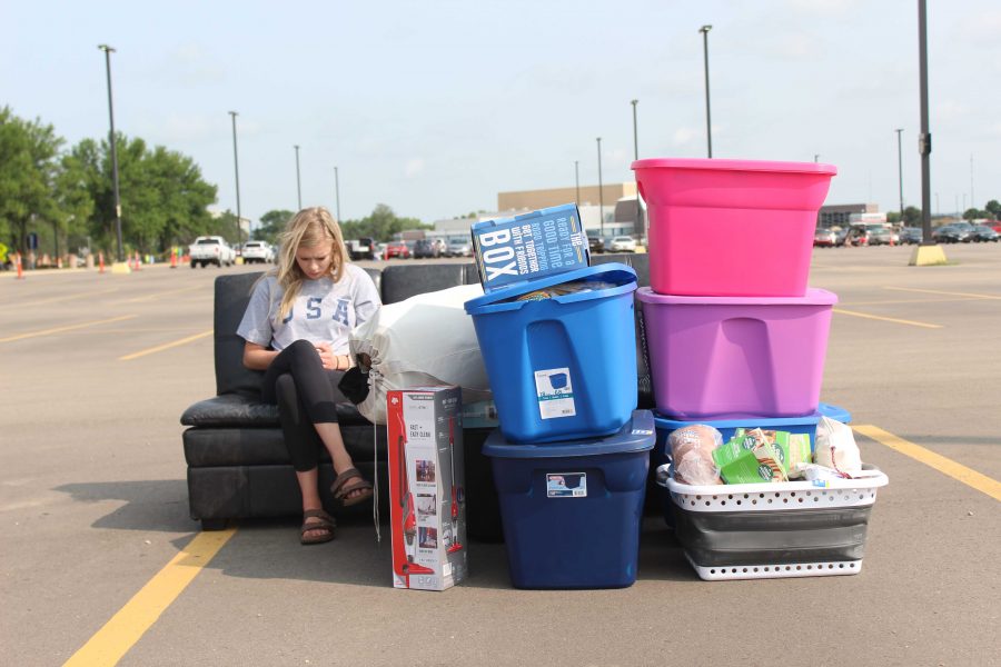 A SDSU sophomore sits with her sisters’ stuff in the parking lot while her sister and parents mover her stuff in her resident hall during Meet State Friday, Aug. 18, 2018 at South Dakota State University.