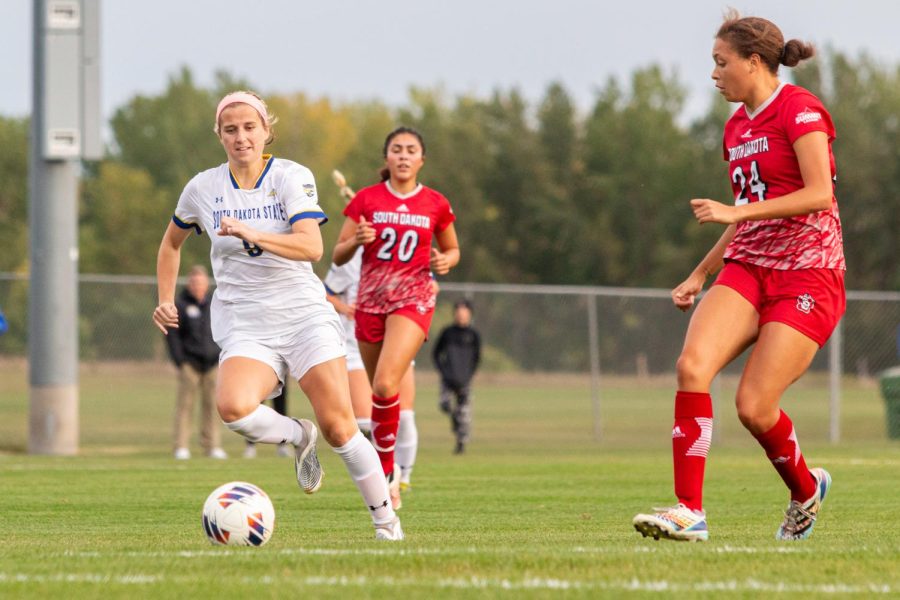 South Dakota State forward Cece Limongi dribbles the ball on USD defender Maliah Atkins (24) in a Summit League soccer game against the  South Dakota Coyotes Saturday night at Fishback Soccer Park. The Jackrabbits and the Coyotes went scoreless for the entire game, ending in a 0-0 tie.
