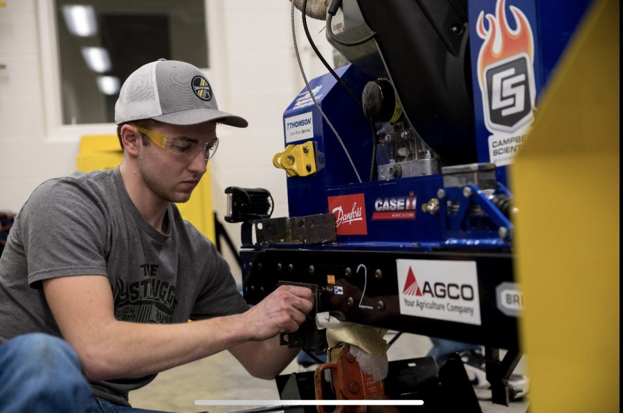 Logan Turgasen works on a quarter scale tractor to prepare for the international competition. 
