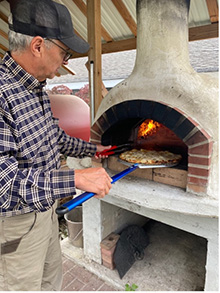 Bill ross, owner of Good Roots Farm and Gardens bakes pizza for customers