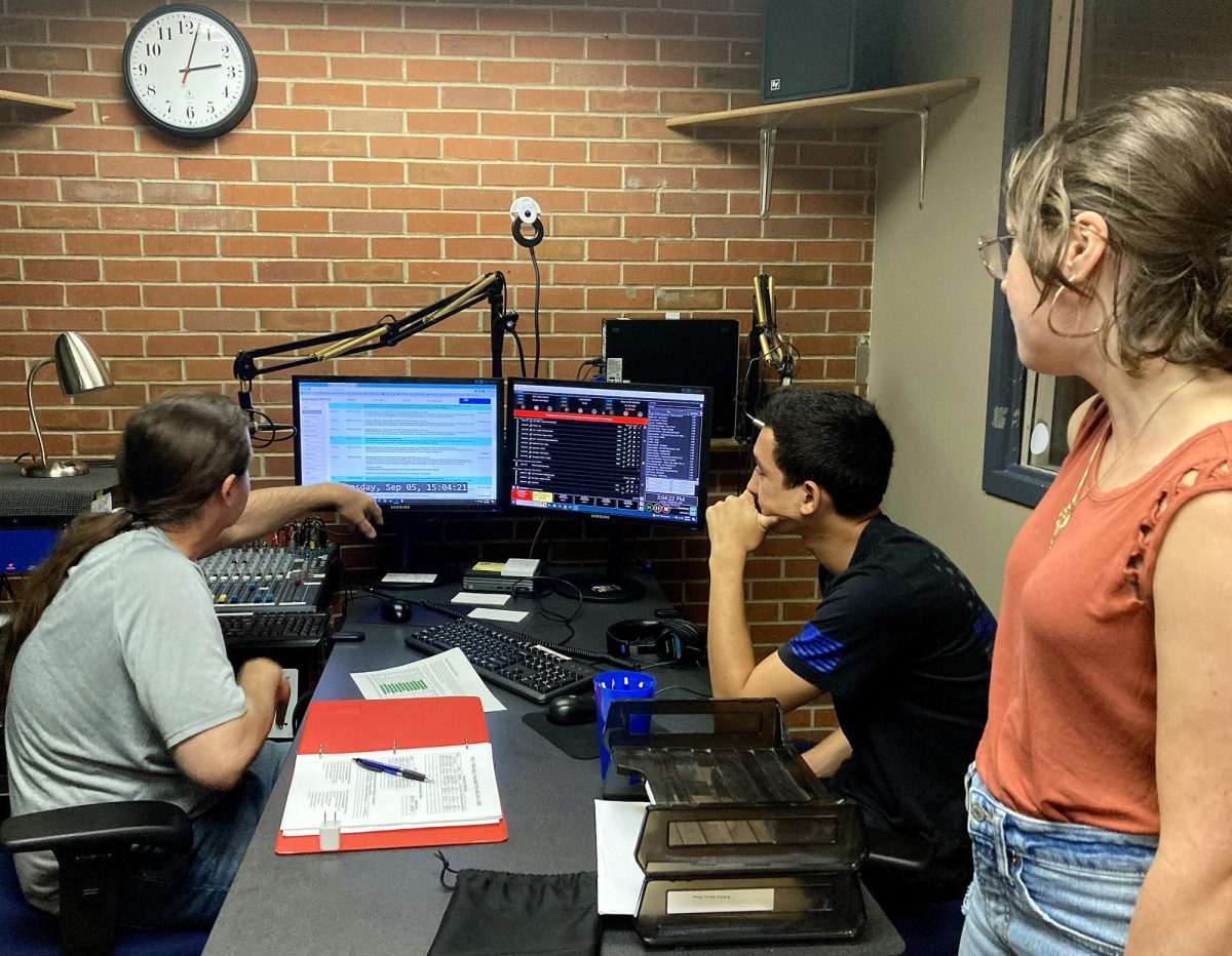 KSDJ Faculty Advisor Brian Stemwedel, left, teaches SDSU students Ben Anderson, center, and Katie Brenholt, right, about KSDJ’s automation and emergency alert systems. KSDJ is celebrating it’s 30th year of providing the SDSU community with music and information.
