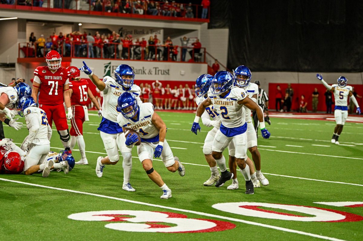 Safety Tucker Large and the Jackrabbit defense celebrate after forcing a turnover against the Coyotes Saturday at the Dakota Dome in Vermillion. Large had 4 total tackles in the win and an interception. 