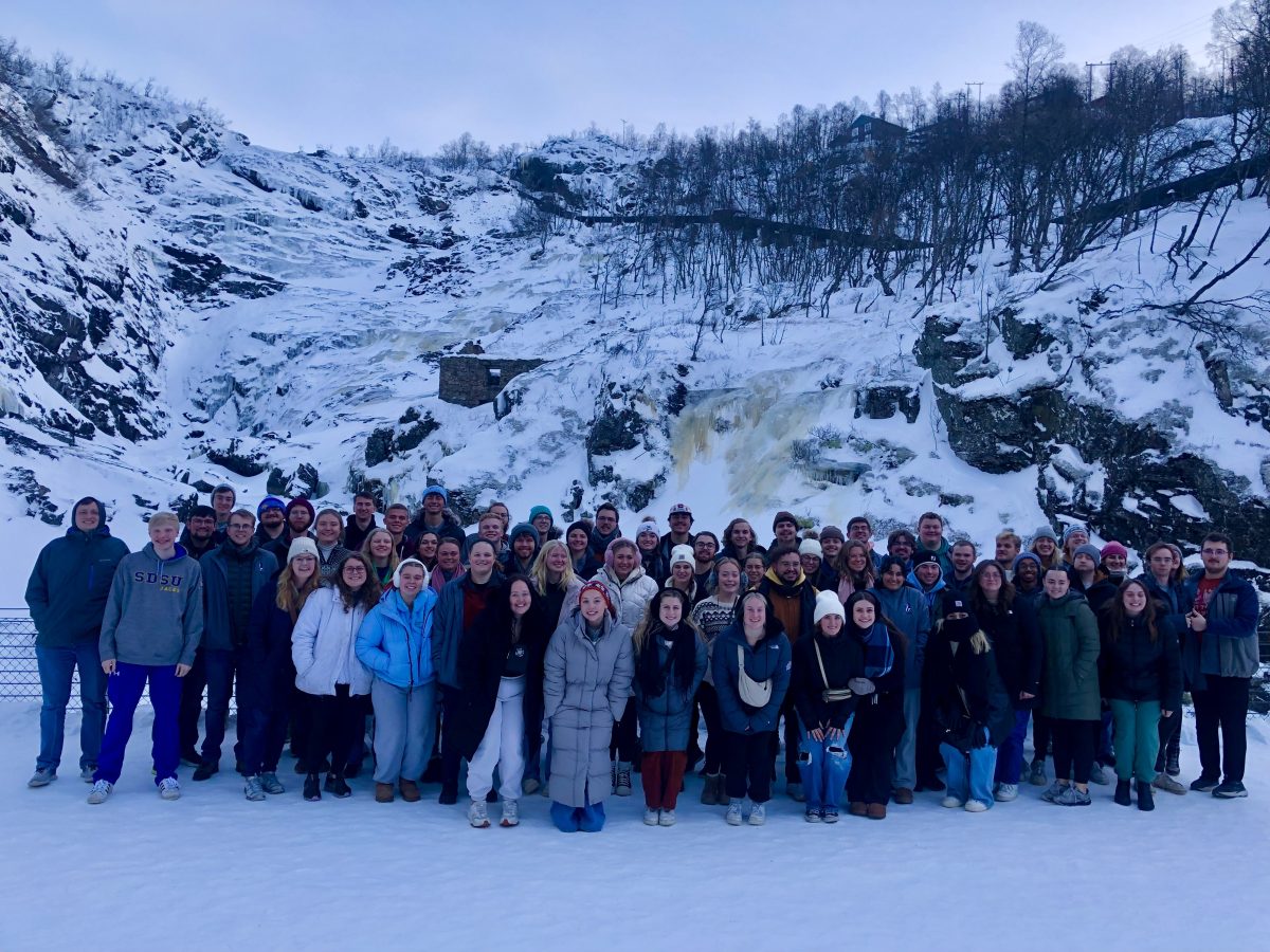 Concert choir stops and smilies for a picture in Fjords, Norway.