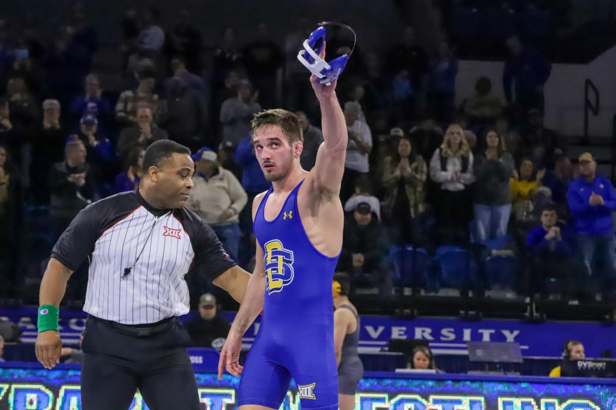 South Dakota State’s Alek Martin raises his headgear after winning his match against his opponent from Northern Colorado during the dual between the two teams Jan. 19, 2024.