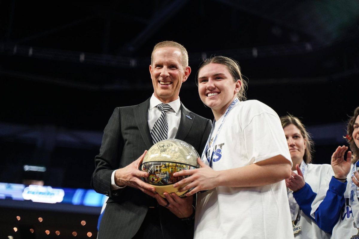 Paige Meyer poses with Summit League Commissioner Josh Fenton after being named tournament MVP.