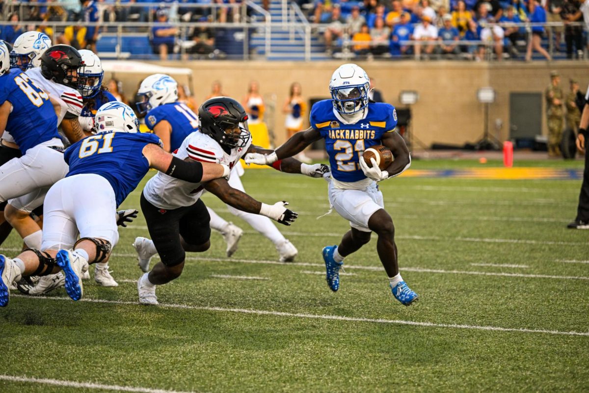 Angel Johnson (21) stiff arms an opposing player as he stretches his run to the outside. Johnson has 69 yards on the season and has 12 rushes. 