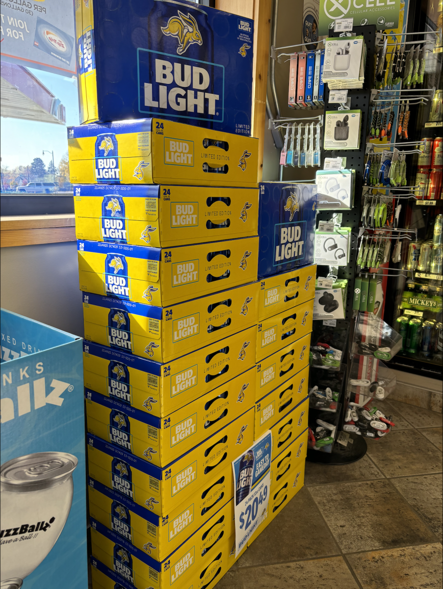 A stack of SDSU-themed Bud Light cases sits on the floor of a Brookings area convenience store.