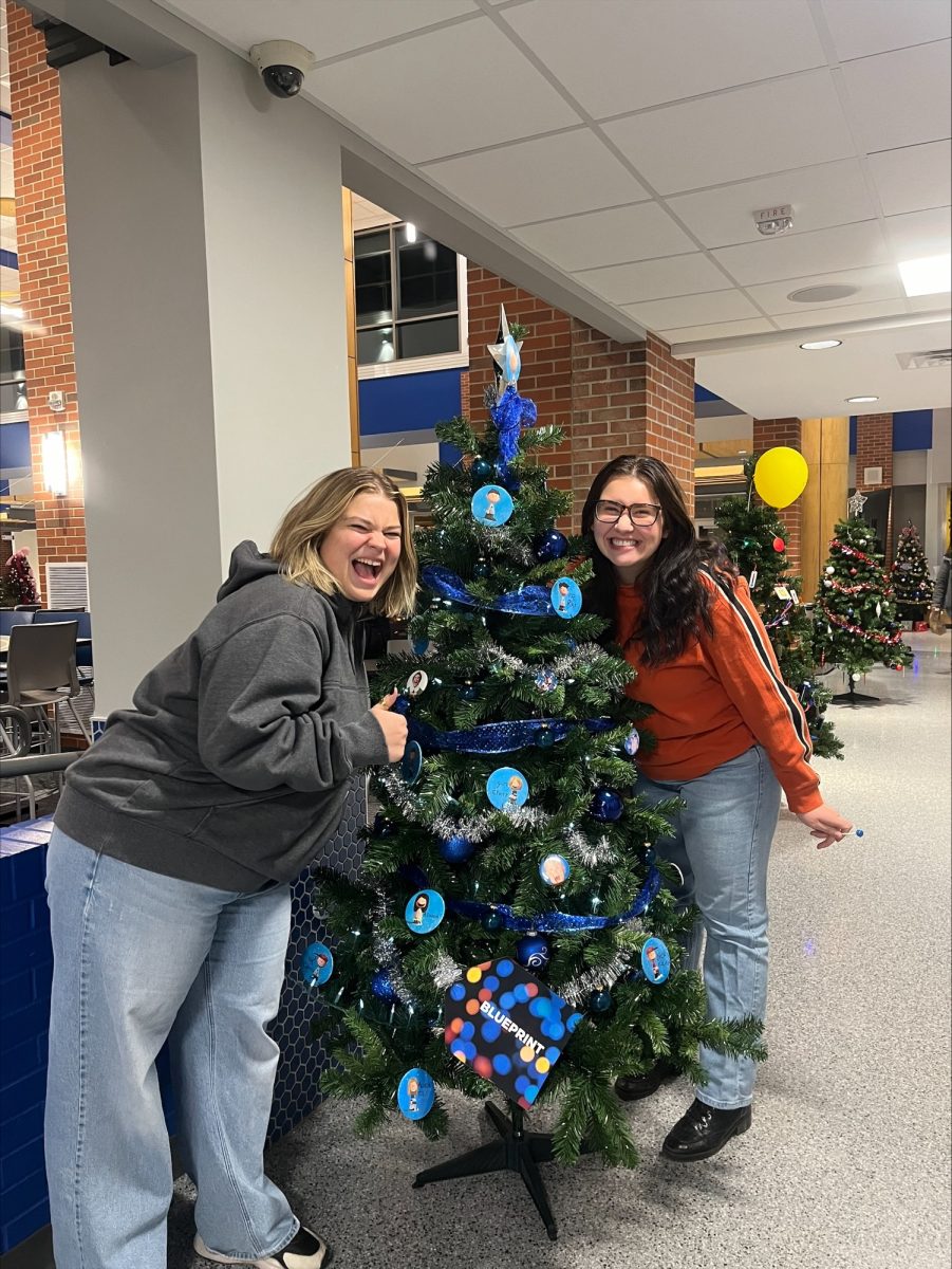 Abby Johnson and Grace Fritz decorating the Blueprint Christmas Tree in the Student Union.