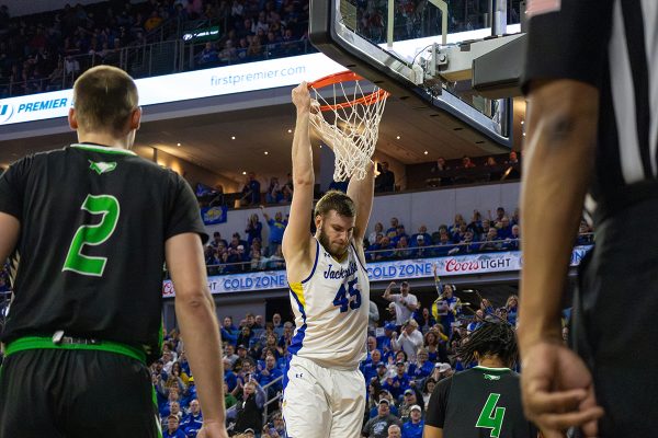 SDSU's Oscar Cluff (45) hangs on the hoop after a dunk during the Jackrabbits' 85-69 loss in the Summit League Championships quarterfinals to North Dakota on Friday at the Denny Sanford PREMIER Center in Sioux Falls.