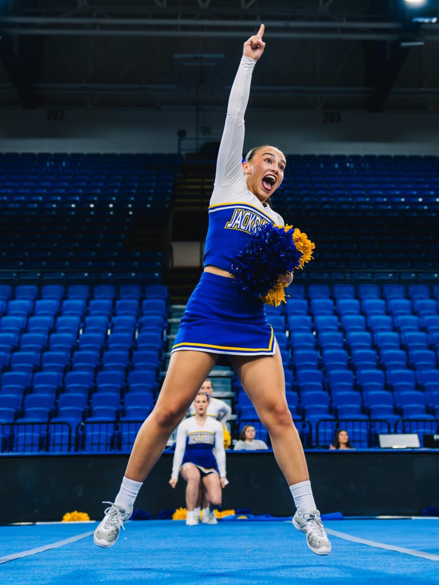 Freshman Mia Jensen hypes up the crowd during the cheer team’s gameday routine. The team earned eighth place in the All-Girl D1 Game Day division. 