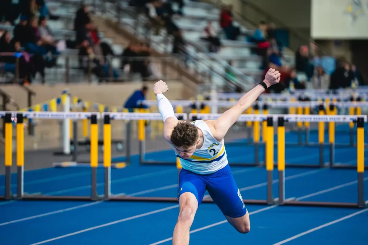 Senior athlete Ryan Benson competes in the hurdles on Jan.24 during the Jim Emmerich Alumni Meet.