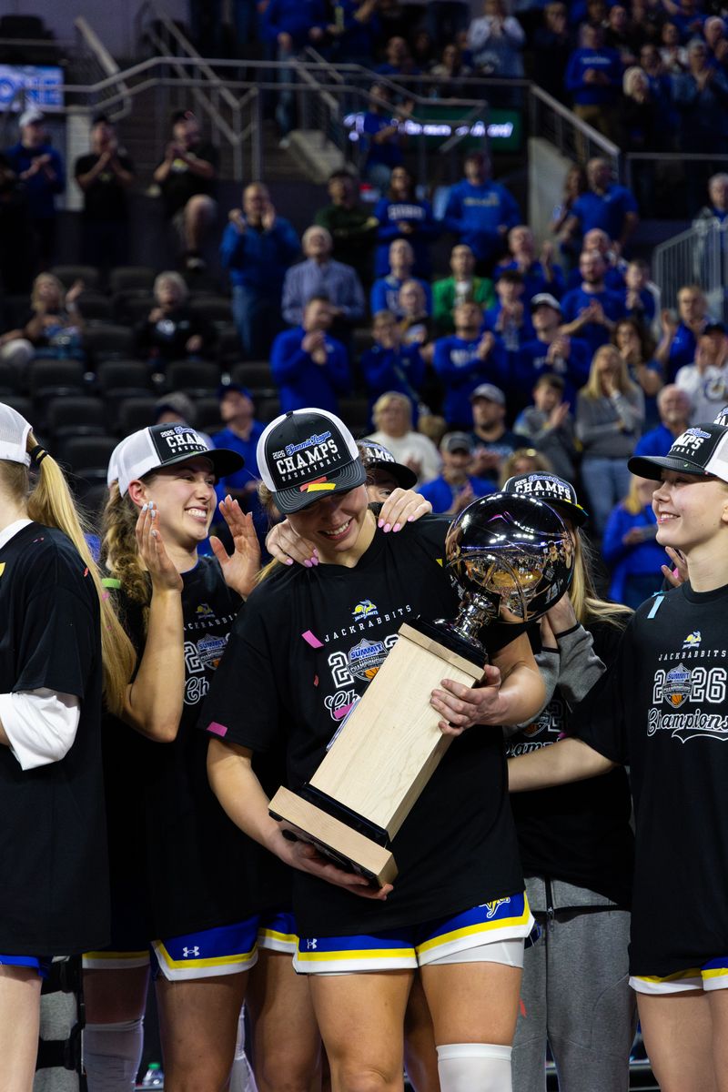  Senior Brooklyn Meyer holds the Summit League trophy surrounded by her teammates after defeating NDSU to win the Summit League Tournament on Sunday March 8.