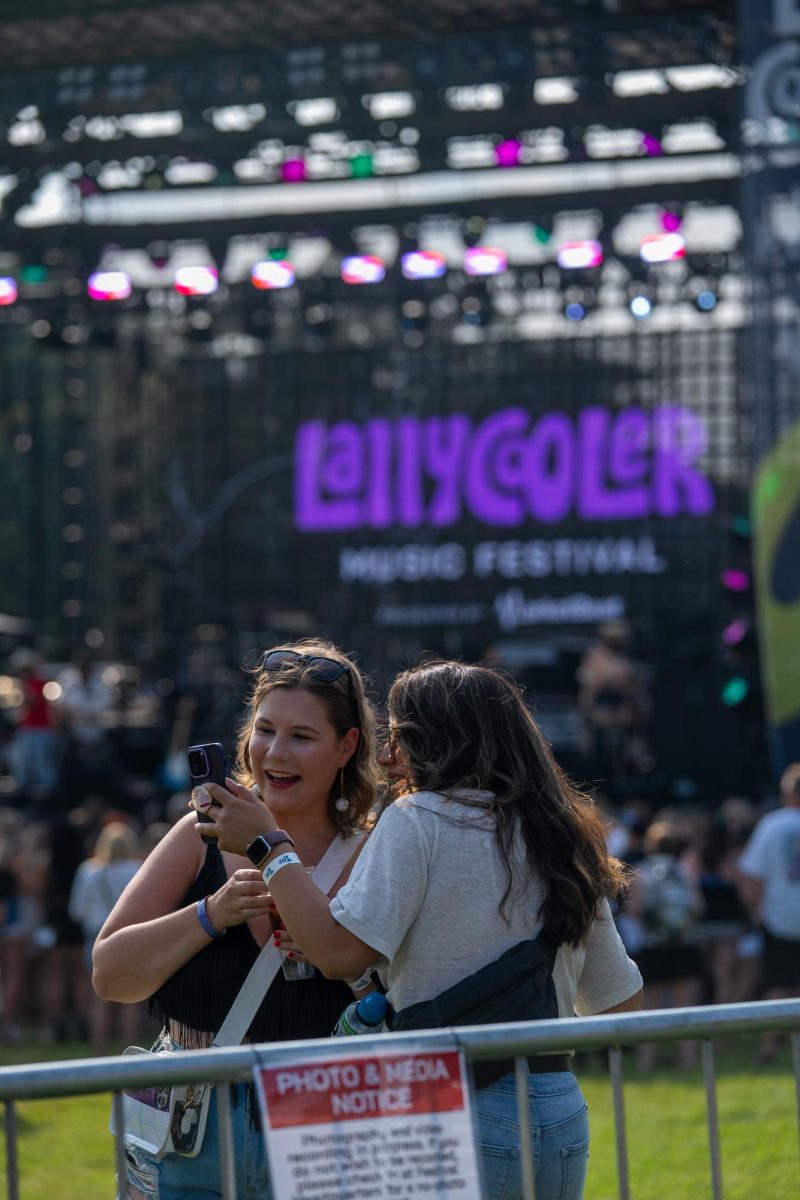 Two festival-goers look at a selfie while attending the inaugural Lallycooler Music Festival located in Sioux Falls in 2025 . For its second year, Lallycooler will be in a new location; Sioux Falls Stadium, home of the Sioux Falls Canaries.