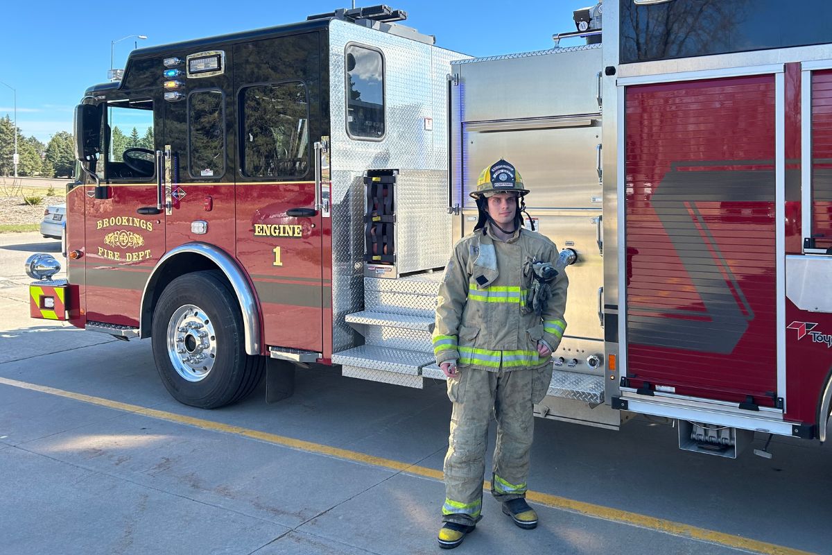 Drew Harding poses in front of Engine 1  on April 8, 2026 in Brookings S.D. Harding is the only SDSU student volunteer firefighter at the Brookings Fire Department.