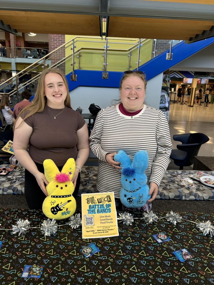 Emma Raisanen, History Club president (left) and Karli Haack, History Club fundraising manager (right) table in the Student Union this week to get the word out about the 80s Rock Battle of the Bands.